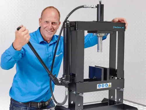 Medewerker van Datona met een werkplaatspers